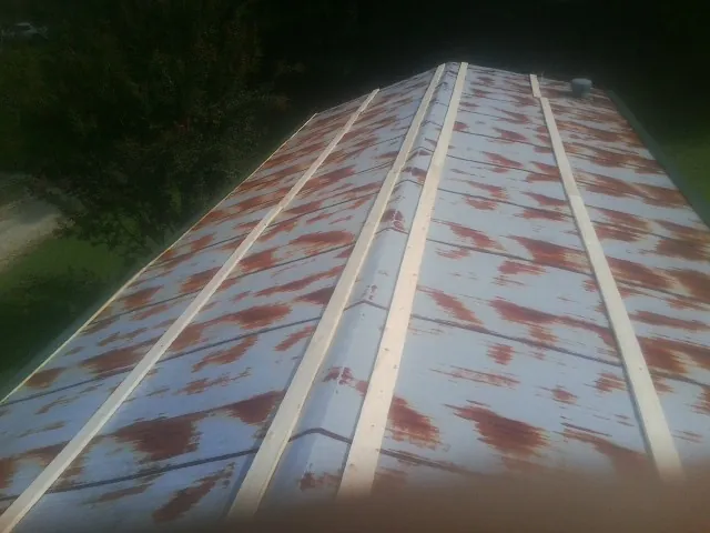 Rusted metal roof panels with new wood purlins before replacement — Storm Damage Roof Repair in Holgate by Roofing Brothers