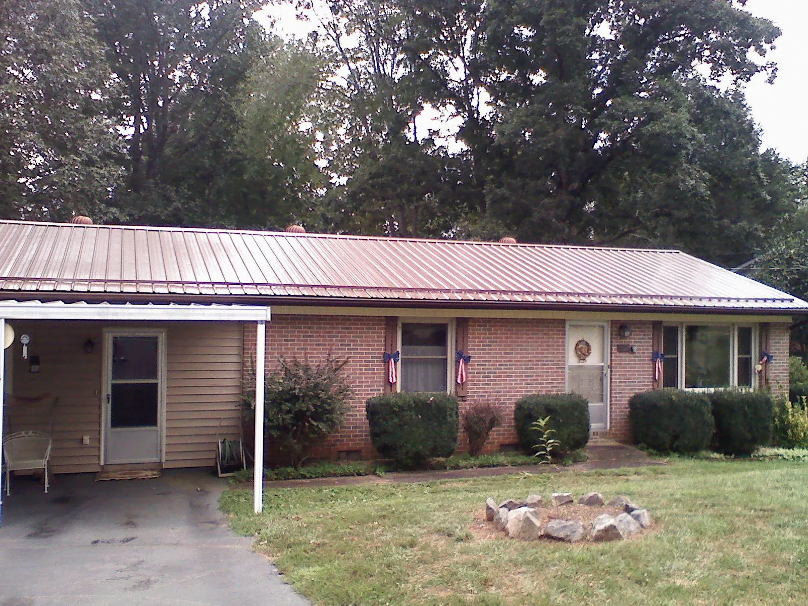 Bronze metal roof and carport on a brick ranch home — Roof Repair work by our crew in Holgate